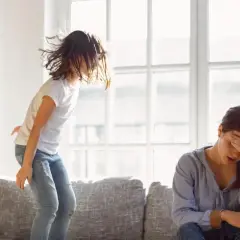 Nerwowy 4 latek skacze po kanapie, podczas gdy jego mama z trudem radzi sobie z jego energią.