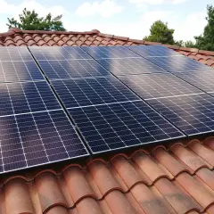 Panneaux solaires sur un toit de tuiles, assurant une production d'énergie durable. La durée de vie panneau solaire est longue.