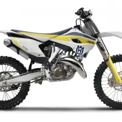 Motocykl Husqvarna cross 125 w białej, żółtej i niebieskiej kolorystyce, gotowy do jazdy po torze.