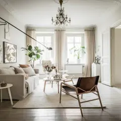 Elegante salón comedor de estilo nórdico. La combinación de lámparas, desde una araña clásica hasta focos modernos, ilumina el espacio.
