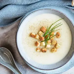 Une onctueuse soupe savoyarde, garnie de croûtons dorés et de ciboulette fraîche, prête à réconforter.