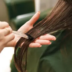 Manos aplicando tinte en el cabello. Cuidado con la alergia al tinte de pelo.