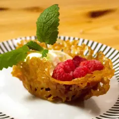 En dessert med glass, hallon och mynta i en krispig knäckflarnskorg. Perfekt till glass!