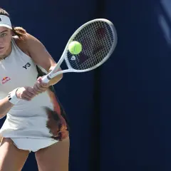 Fernandez tenisistka w akcji, uderza piłkę rakietą.