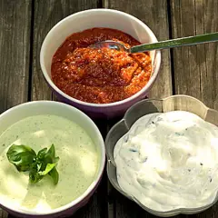 Tre skålar med olika såser till grillat: en röd, en grön med basilika och en vit med örter. Perfekt för sommarens middagar!