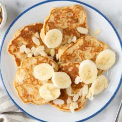 Deliciosas tortitas de plátano, adornadas con rodajas de plátano y almendras laminadas. Una receta perfecta para un desayuno o merienda.