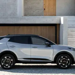 Nowoczesny Kia Sportage prezentuje swoje dynamiczne linie i imponujące kia sportage wymiary na tle minimalistycznej architektury.