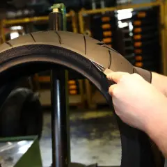 Inspección de un neumático de moto para determinar cada cuanto cambiar neumaticos moto. Se revisa el desgaste y la profundidad del dibujo.