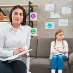 Psycholog z notatkami podczas sesji z dzieckiem. To przykład przygotowania pedagogicznego dla psychologów, wspierającego rozwój emocjonalny najmłodszych.