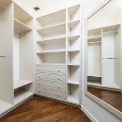 Spazioso armadio a muro in cartongesso con ripiani, cassettiera e specchio.