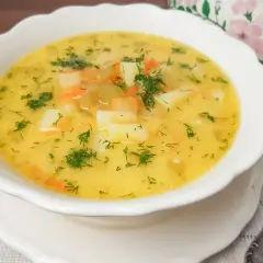Aromaticzna zupa ogórkowa z ziemniakami i marchewką, posypana świeżym koperkiem. Idealna na chłodne dni.