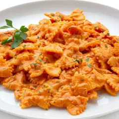Un plato de pasta farfalle con una cremosa salsa de tomate y un toque de perejil. ¡Así es que es farfalle!