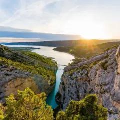 Solnedgång över Gorges du Verdon, med en turkos flod som slingrar sig mellan dramatiska klippor och frodig grönska.