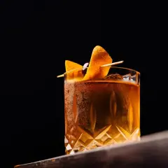 Elegancki drink z pomarańczą i wiśnią, idealny do degustacji. Czy to klasyczny Old Fashioned z dodatkiem angostura?