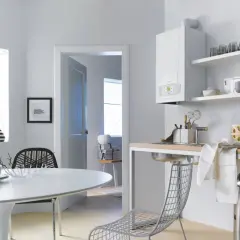Nowoczesny piec gazowy 24kw, idealny do ogrzania domu o powierzchni do 150m2, zamontowany w jasnej kuchni z jadalnią.