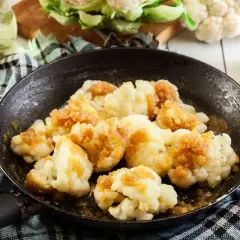 Cavolfiore gratinato in padella, dorato e croccante, pronto per essere gustato. Un contorno semplice e saporito.