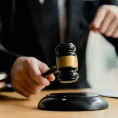 Sędzia trzyma młotek, obok waga sprawiedliwości i księgi. Czy sąd ma obowiązek powiadomić o wyroku?