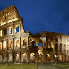 El Coliseo Romano, un ícono de la arquitectura antigua, iluminado bajo el cielo nocturno.
