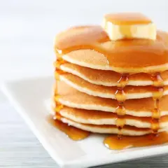 Pila de panqueques esponjosos con mantequilla y miel, perfecta para tu próxima receta.