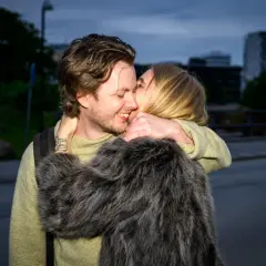 Amanda Romare och hennes lilleman omfamnar varandra lyckligt i skymningen.