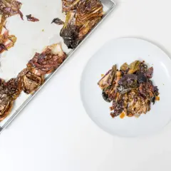 Gerösteter Radicchio, ein einfaches italienisches Rezept, liegt auf einem Blech und auf einem Teller.