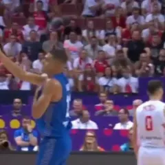 Koszykarz w niebieskim stroju gestykuluje na tle trybun, gdzie widać kibiców w biało-czerwonych barwach. Mecz Izrael Polska.