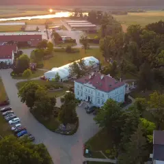 Widok z lotu ptaka na hotel Jakubus z otaczającym go parkiem i stawem w tle.