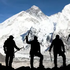 Pięciu alpinistów z czekanami na tle ośnieżonego Mount Everestu. To symboliczne przedstawienie, bo ile osób weszło na Mount Everest, to już inna historia.