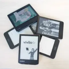 Pile d'e-readers Kobo et Vivlio, certains affichant des couvertures de livres ou des illustrations. Le logiciel Kobo est visible sur plusieurs appareils.