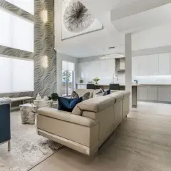 A modern living room with a textured wall, blue velvet chairs, and a cream sofa. The interior design color schemes feature beige, navy, and grey swatches.