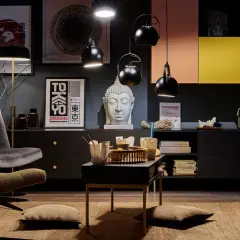 Salon w stylu eklektycznym: szara sofa, fotel, stolik z bambusową tacą, głowa Buddy, plakaty z Japonii i Azji.