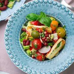 En färgstark sallad med grillad halloumi, tomater, oliver, bönor och granatäpple. Ett perfekt sallad recept för en lätt lunch.