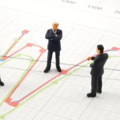 Trzej biznesmeni analizują wykresy, szukając dywersyfikacji strategii.