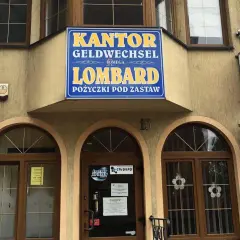 Elewacja budynku z szyldem "KANTOR GELDWECHSEL LOMBARD POŻYCZKI POD ZASTAW".
