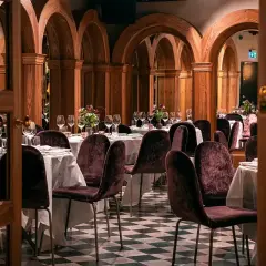 Elegant bank hotel lunch setting with plush chairs and arched wooden decor.