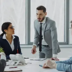 Zespół biznesowy w biurze omawia dokumenty przy stole.