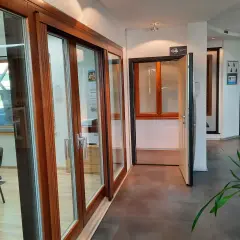 Salon okien i drzwi z drewnianymi ramami, przeszklonymi drzwiami i otwartymi drzwiami.