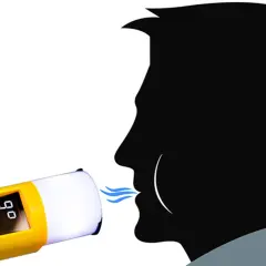 Alkomat pokazuje 0,90 mg/l. Mężczyzna dmucha w urządzenie, sprawdzając poziom alkoholu.