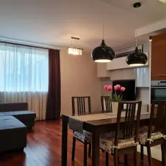 Nowoczesny salon z jadalnią, kanapą, stołem i kwiatami.