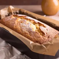 Frisch gebackener Kuchen in einer Kastenform, mit Puderzucker bestäubt. Ein köstlicher Anblick, der zum Reinbeißen einlädt. Dreh dich um, Kuchen, du bist perfekt!