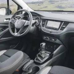 Interior del Opel Crossland X con asientos grises y negros, volante multifunción y pantalla táctil.