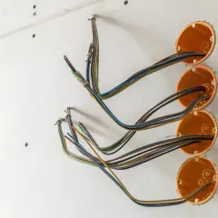 Instalacja elektryczna w trakcie prac. Widoczne puszki instalacyjne i przewody, czekające na maskownicę na ścianę.