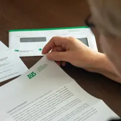 Osoba przegląda dokument ZUS. Może to być informacja o stanie konta lub zwrot nadpłaty.