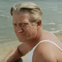 Józef Nowak, aktor, odpoczywa nad wodą w białej podkoszulce.