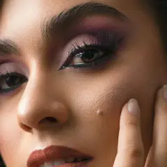 Un regard intense avec un maquillage des yeux en noir, rehaussé de fard à paupières violet.
