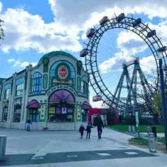 Una famiglia passeggia verso la ruota panoramica del Prater, un'attrazione iconica per una gita a Vienna con i bambini.