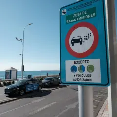 Señal de "Zona de Bajas Emisiones" (ZBE) con un coche y puntos de emisión. Indica excepciones para vehículos con distintivos C, ECO y 0.
