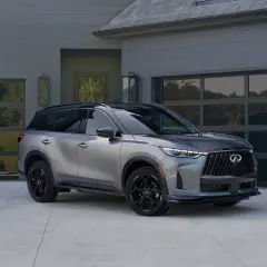 Srebrny infinity auto przed nowoczesnym domem z garażem.
