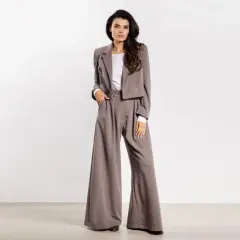 Elegancki strój kobiecy do filharmonii: krótka marynarka i szerokie spodnie w odcieniu taupe.