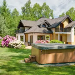 Piękny dom z ogrodem, gdzie jacuzzi ogrodowe aranżacje tworzą oazę relaksu. Kwitnące krzewy dodają uroku.